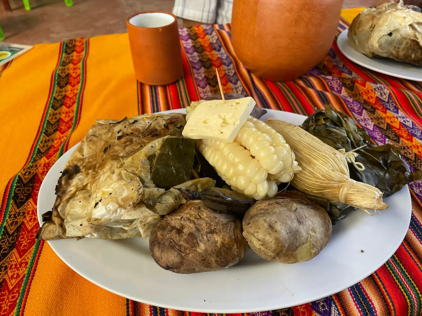 Plate of Andean food with potatoes, corn and humitas
